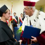 Rektor wręcza dyplom ukończenia studiów wyróżnionej studentce